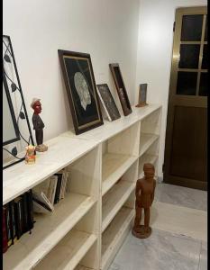 Una estantería blanca con libros y una muñeca. en Villa Stella en Lomé