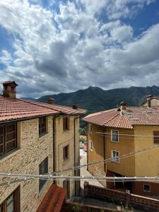 une vue sur deux bâtiments avec des montagnes en arrière-plan dans l'établissement La casa di Franco, à Ruosina