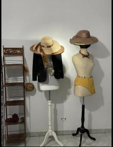 dos maniquíes y sombreros expuestos en una pared en Villa Stella, en Lomé