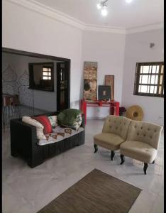 sala de estar con sofá y silla en Villa Stella en Lomé