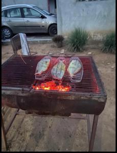 four chickens are cooking on a barbecue grill at Villa Stella in Lomé
