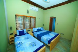 a bedroom with two beds and a window at Ammu villa in Point Pedro