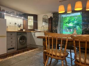 a kitchen with a table and a washing machine at French Gite Style Garden Apartment, Central Taunton in Taunton