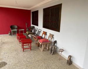 una sala de estar con paredes rojas y sillas rojas. en Villa Stella en Lomé