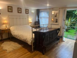 - une chambre avec un lit, une table et une fenêtre dans l'établissement French Gite Style Garden Apartment, Central Taunton, à Taunton