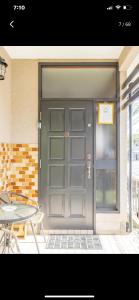 a gray garage door with a table and a patio at Bonel Guest House in Tomisato