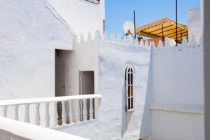 ein weißes Gebäude mit einer Treppe und einer Tür in der Unterkunft Riad Dar Lina in Rabat