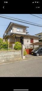 uma casa com um carro estacionado em frente em Bonel Guest House em Tomisato