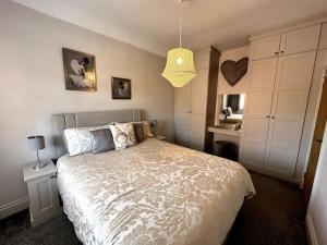 a bedroom with a bed and a pendant light at A character property close to Lichfield Cathedral in Lichfield