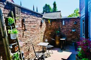 a patio with a brick wall and a table and chairs at A character property close to Lichfield Cathedral in Lichfield