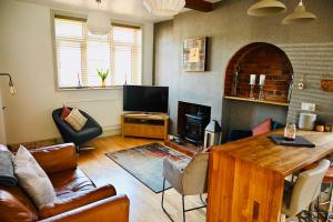 sala de estar con sofá, mesa y TV en A character property close to Lichfield Cathedral, en Lichfield