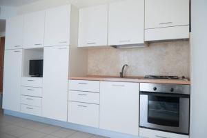 a kitchen with white cabinets and a stove at Casa Del Mar in Roseto degli Abruzzi