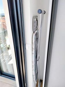una puerta de cristal con un teléfono colgando en una pared junto a una ventana en Apartment with a sea view., en Tivat