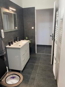 a bathroom with a white sink and a toilet at Dóra vendégház in Letenye +8 photos