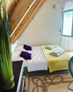 a bedroom with a bed with a yellow blanket and a window at Dream House in Plužine