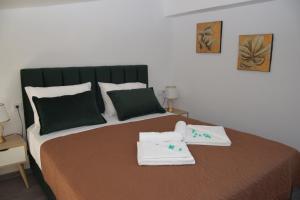 um quarto com uma cama grande e toalhas em Olympia Suites em Pirgos