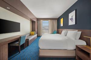 a hotel room with a large bed and a desk at voco Makkah by IHG in Mecca +81 photos