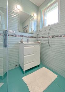 een badkamer met een witte wastafel en een douche bij Kékszalag Vendégház in Tihany
