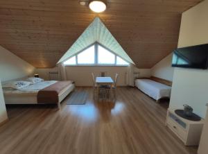 een slaapkamer met 2 bedden, een tafel en een raam bij Widok apartamenty domki pokoje 725 -258 -751 in Polańczyk