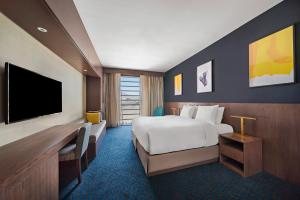 a hotel room with a bed and a flat screen tv at voco Makkah by IHG in Mecca