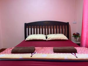 una camera con un letto con due cuscini sopra di Happy Resort a Khanom