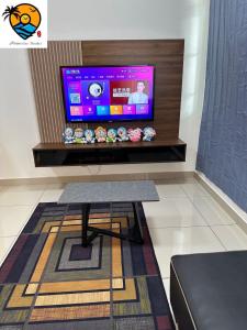 sala de estar con TV y mesa de centro en ZZZ HOMESTAY SKUDAI, en Skudai