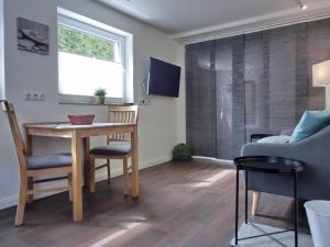 a living room with a table and chairs and a window at Ferienwohnung MH1 "Blue Ocean" in Rostock +1 photo