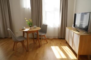 een woonkamer met een tafel met 2 stoelen en een televisie bij Studio in the city center in Rīga
