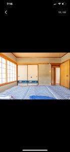 a bedroom with a large bed with blue sheets at Bonel Guest House in Tomisato