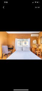 1 dormitorio con cama, escritorio y silla en Bonel Guest House en Tomisato