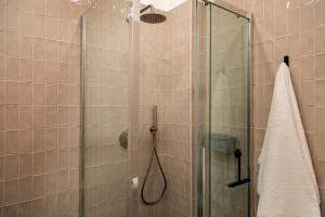 een badkamer met een douche met een glazen deur bij Nella's Holiday in Cefalù