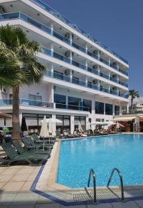 una piscina con sedie e un grande edificio di Palmea Hotel a Marmaris