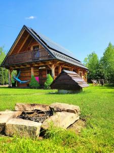 a log cabin with a rock in front of it at Hyta na Bani- domek Rabka Zdrój in Skawa