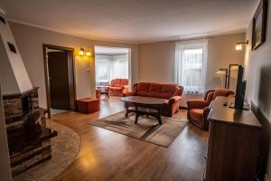 a living room with orange chairs and a fireplace at Nad Zatoką in Bryzgiel