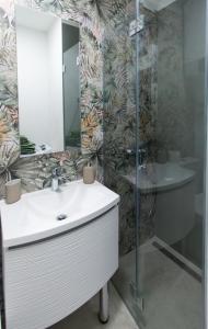 ein Bad mit einem Waschbecken, einem Spiegel und einer Dusche in der Unterkunft Studio apartman Irma Červar in Poreč