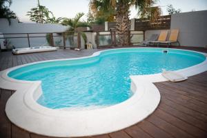 - une piscine au milieu d'un patio dans l'établissement La case à Nath - Piscine chauffée et jacuzzi, à Saint-Pierre