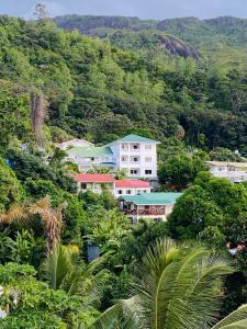 a building in the middle of a hill with trees at Oceanic View Apartments in Beau Vallon