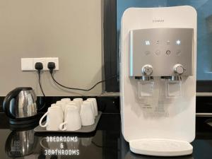 uma máquina de café na cozinha com algumas chávenas brancas em Vista Residences Genting Highlands Free WiFi & 1 Parking em Genting Highlands