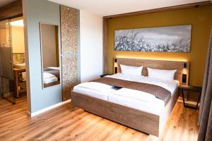Hotel Spinnerhof في ساسباخفالدن: غرفة نوم بسرير ودهان على الحائط