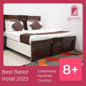 a bed with brown and white sheets and pillows at Qotel Hotel Peeragarhi-Near Peeragarhi metro Station,Couple Friendly in New Delhi