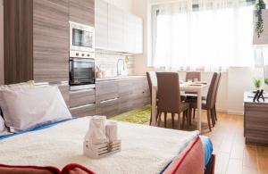 a bedroom with a bed and a kitchen with a table at Vera Project Apartment in Milan