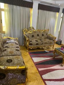 ein Wohnzimmer mit einer goldenen Couch und einem Tisch in der Unterkunft شقه مفروشه للايجار على البحر مباشره بالزقازيق in Kafr az Zand
