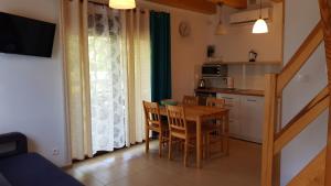 a kitchen and dining room with a table and chairs at Domki letniskowe,apartamenty Wczasowa 8a in Sianozety