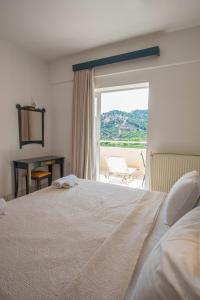 sypialnia z łóżkiem i widokiem na patio w obiekcie Antonis Studios & Apartments w mieście Plakias