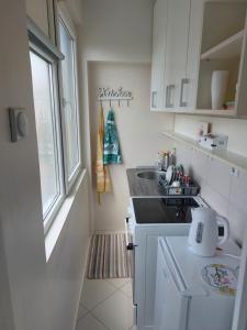 a small kitchen with a sink and a window at Apartman Kokin Grad in Prijedor