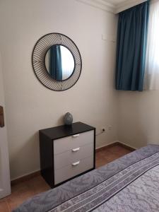 a bedroom with a dresser and a mirror on the wall at Club La Mar 62 in Puerto de Santiago +30 photos