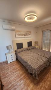 1 dormitorio con 1 cama y 1 lámpara en el suelo de madera en La Manga del Mar Menor Los Miradores block 1 5th floor G, en Murcia
