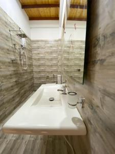 ein Badezimmer mit einem weißen Waschbecken und einem Spiegel in der Unterkunft The Reef Resort in Nilaveli