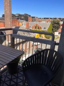 a black chair sitting on a balcony with a table at Solsiden, 2 soverom med parkering in Trondheim