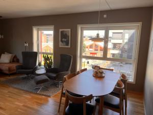 a dining room with a table and chairs and a living room at Solsiden, 2 soverom med parkering in Trondheim